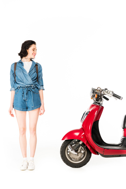 full length view of girl looking at red scooter isolated on white - 写真・画像