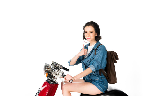 girl sitting on red scooter and showing thumb up isolated on white - Foto, Imagem