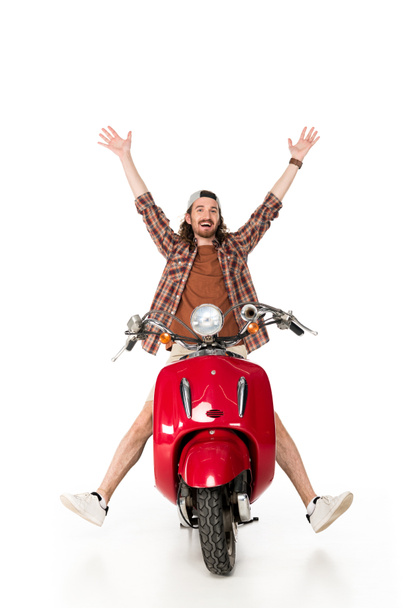 elleri havada olan mutlu genç adamın tam uzunlukta görünümü, beyaz izole kırmızı scooter üzerinde oturan - Fotoğraf, Görsel