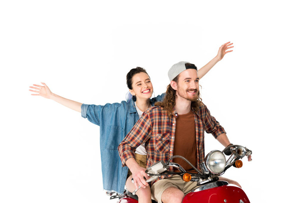 couple of young tourists riding on red scooter holding hands in air isolated on white - Foto, Bild