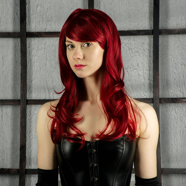 Portrait de fille aux cheveux roux dans un corset en cuir
 - Photo, image