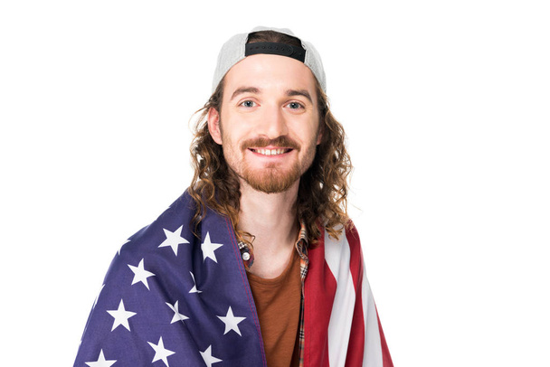 muotokuva nuoresta komeasta miehestä, jolla on Amerikan lippu hartioilla, katselemassa kameraa, joka on eristetty valkoisella
 - Valokuva, kuva