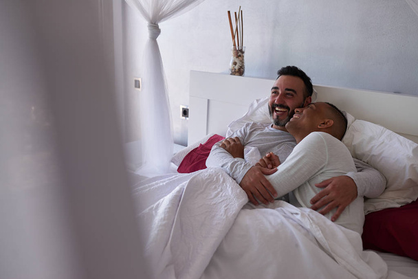 rotujenvälinen homo pari sängyssä
 - Valokuva, kuva