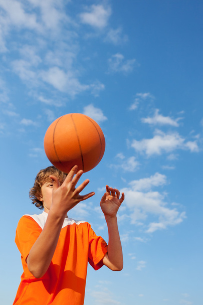 Basketball Player Spinning Ball Against Sky - Φωτογραφία, εικόνα