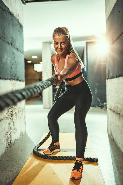Молода м'язиста жінка займається з мотузкою в спортзалі
 - Фото, зображення