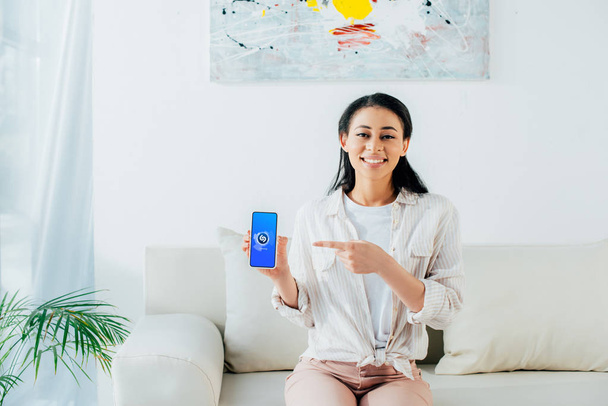 KYIV, UKRAINE - APRIL 26, 2019: Pretty latin woman holding smartphone with Shazam app on screen.  - 写真・画像