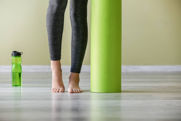 Jovem mulher esportiva com tapete de ioga no ginásio
 - Foto, Imagem