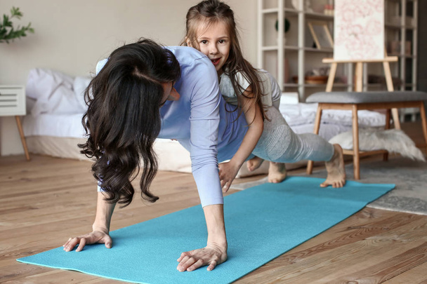 Mãe com filhinha fazendo exercícios em casa
 - Foto, Imagem
