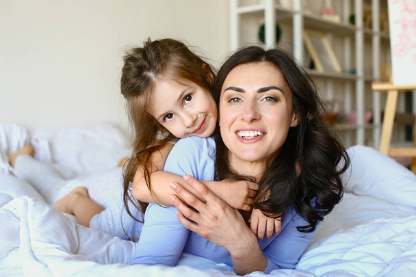 glückliche Mutter mit Tochter, die zu Hause ruht - Foto, Bild