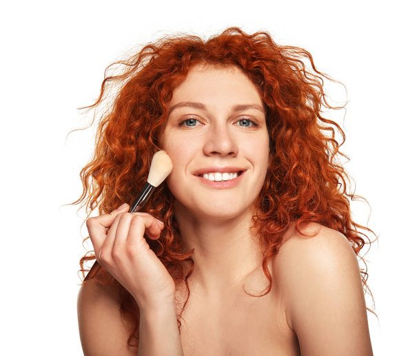 Beautiful young woman applying makeup on white background - Фото, зображення