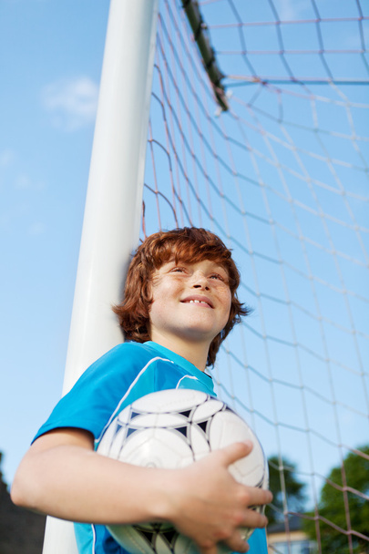 Little Boy Holding Soccer Ball While Leaning On Net Pole - Zdjęcie, obraz