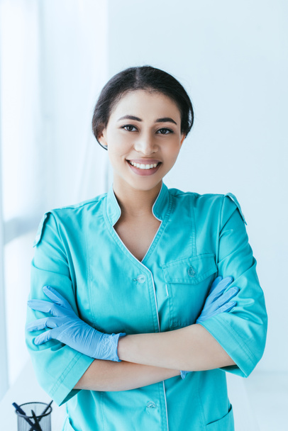 pretty latin woman standing with crossed arms and smiling at camera  - Foto, afbeelding