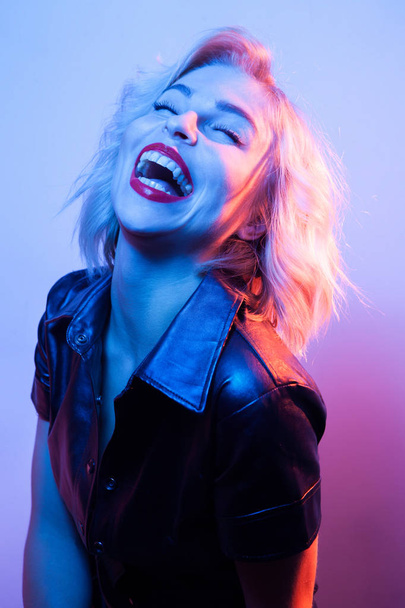 Attractive laughing woman dressed in fashion apparel in neon night lights. - Zdjęcie, obraz