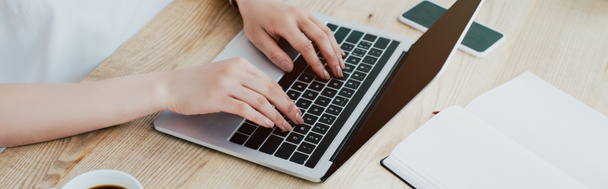 tiro panorâmico de empresária usando laptop enquanto sentado no local de trabalho
 - Foto, Imagem