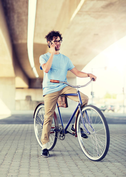 man with smartphone and fixed gear bike on street - Foto, imagen