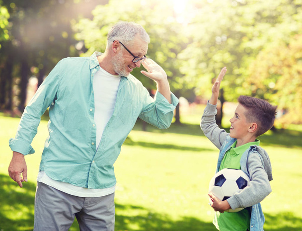 old man and boy with soccer ball making high five - Fotoğraf, Görsel