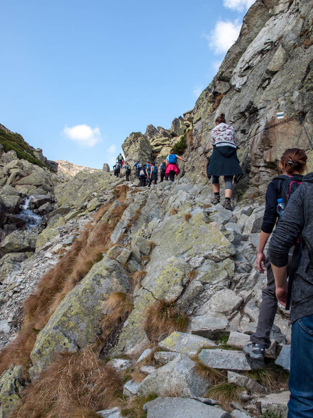 Vysoke Tatry, Slovakia - October 10, 2018: Hikers on trail at Great Cold Valley,  Vysoke Tatry (High Tatras), Slovakia. The Great Cold Valley is 7 km long valley, very attractive for tourists - Photo, Image