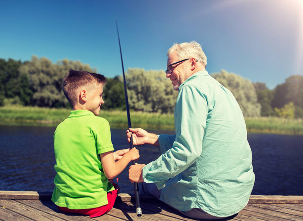 grandfather and grandson fishing on river berth - Zdjęcie, obraz