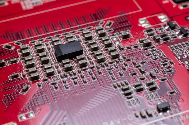 Transistors van de achterkant van de videokaart onder de grafische kern. Macro-opname van een rode microkring. Het concept van een microscopische stad. - Foto, afbeelding