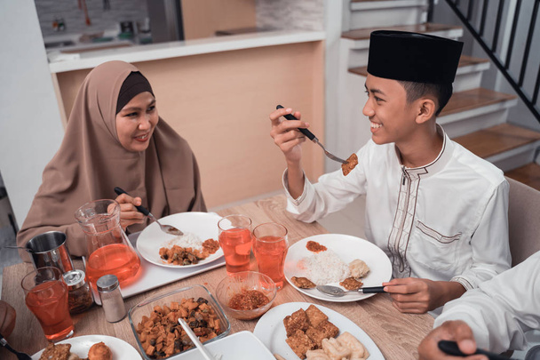muslim mother talking to her son while having dinner together - Fotoğraf, Görsel