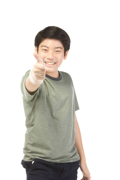 Ασιατικό ενθουσιασμένος αγόρι με πράσινο πουκάμισο δίνοντας τους αντίχειρες-up. - Φωτογραφία, εικόνα