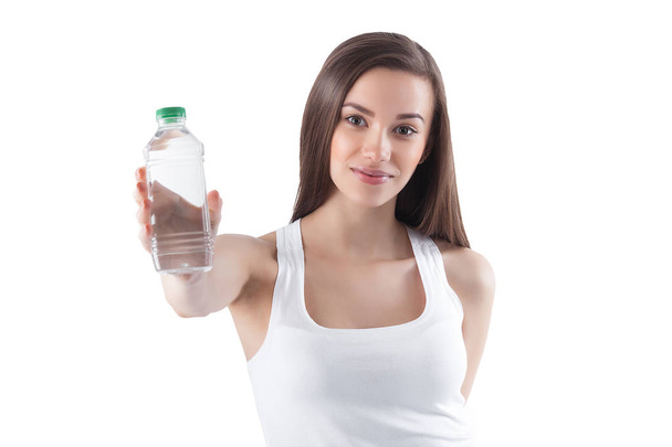 Attractive young woman drinking water on isolated white background. Female holding bottle of water. - Valokuva, kuva