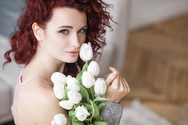 Very attractive young woman indoors. Portrait of curly haired female. Redhaired beautiful woman at home. - Фото, изображение