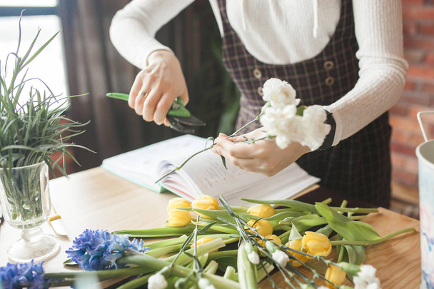 Woman on the master-class on floristics. Young lady making floral composition.  - Foto, Imagem