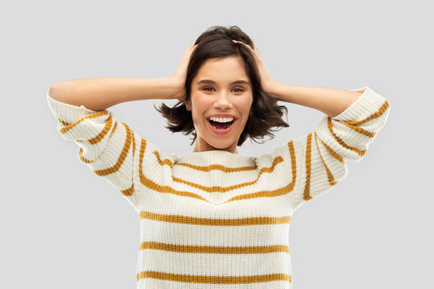 happy woman in pullover holding to her head - Foto, Bild