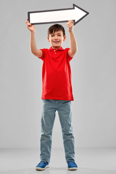 boy holding big white rightwards thick arrow - Foto, Imagen