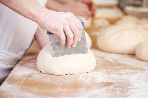 Baker making traditional patterns on bread - Photo, Image