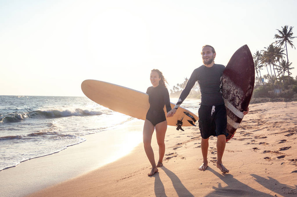 Young beautiful couple of friends with surfboards in their hands, sports, active lifestyle - Foto, Bild