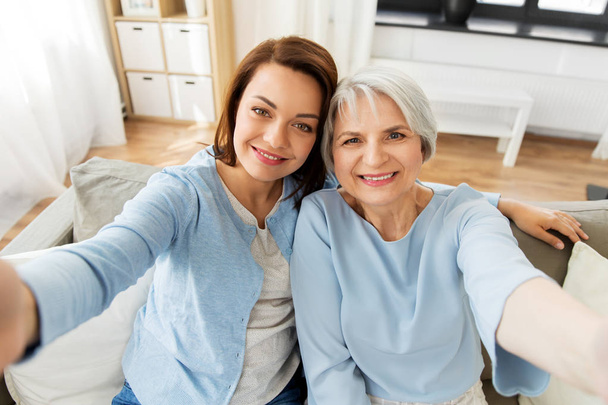senior mother and adult daughter taking selfie - Photo, Image