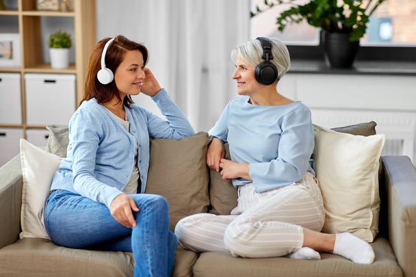 senior mother and adult daughter with headphones - Фото, зображення