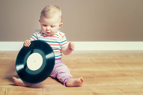 Petite fille jouant avec un disque vinyle avec étiquette vide
 - Photo, image