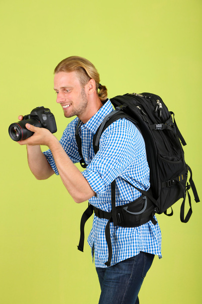 Handsome photographer with camera, on green background - Fotó, kép