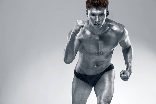 Runner or sprinter concept. Brutal strong muscular bodybuilder athletic man run on light background. Workout bodybuilding banner. - Photo, Image