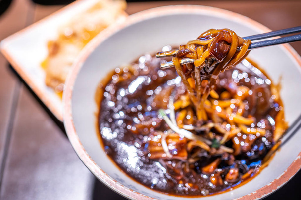 Jajangmyeon, jjajangmyeon, fried sauce noodle, delicious korean traditional noodles cuisine with korea black bean paste sauce, close up, copy space - Foto, Imagem