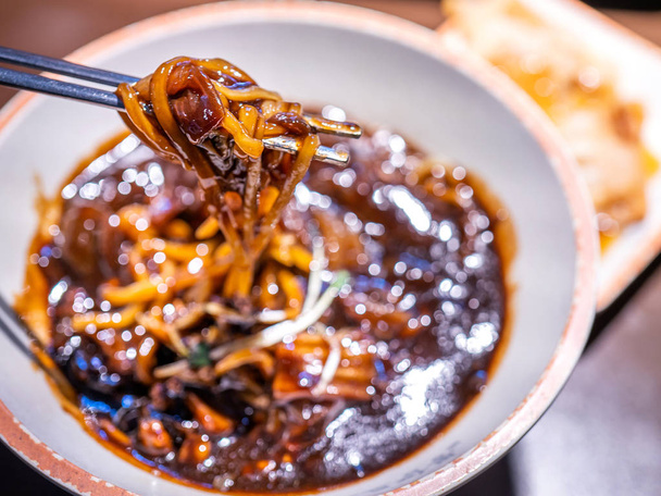 Jajangmyeon, jjajangmyeon, fried sauce noodle, delicious korean traditional noodles cuisine with korea black bean paste sauce, close up, copy space - Foto, Imagem