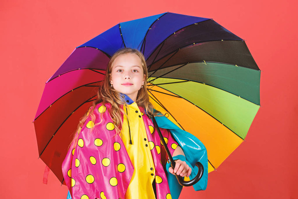 Waterproof accessories make rainy day cheerful and pleasant. Kid girl happy hold colorful umbrella wear waterproof cloak. Enjoy rainy weather with proper garments. Waterproof accessories manufacture - Foto, Imagen