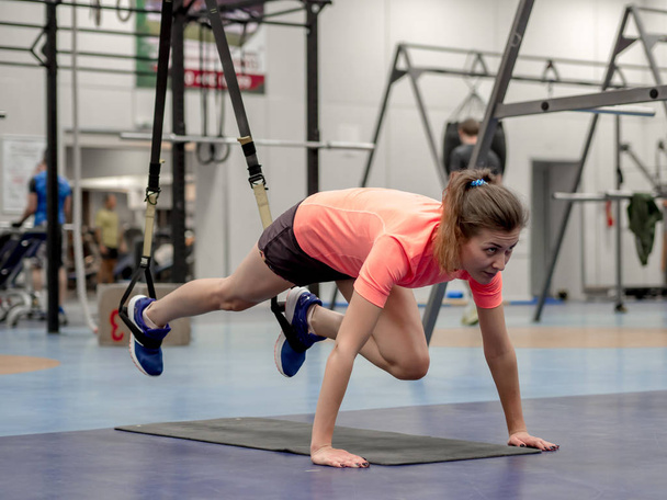 Chica modelo joven hace ejercicios en el gimnasio frente al espejo
  - Foto, imagen