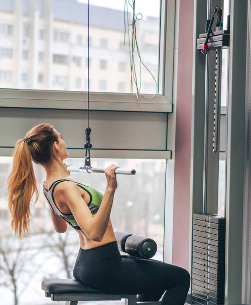 Молодая девушка делает упражнения в спортзале
 - Фото, изображение
