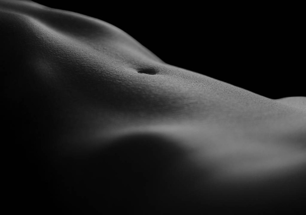 Naked woman silhouette tummy and legs isolated at black - Photo, image