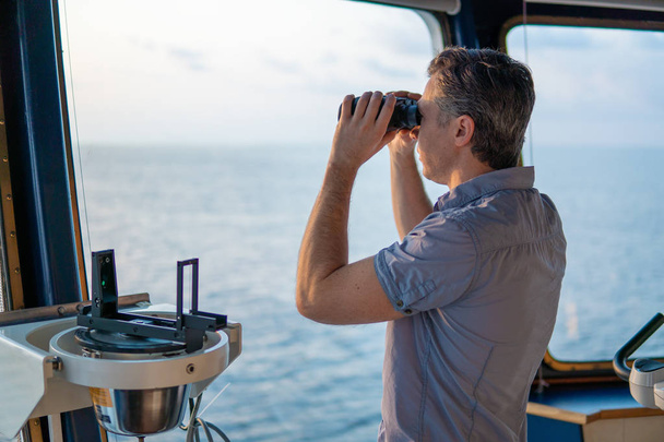 Navigational officer lookout on navigation watch with binoculars - Photo, Image