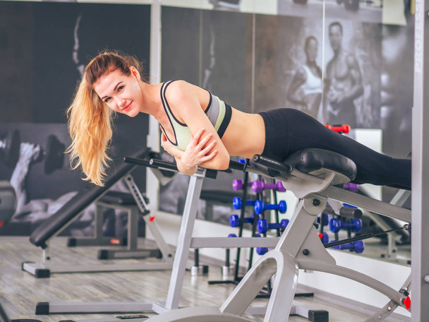 Young girl makes exercises at the gym - Fotoğraf, Görsel