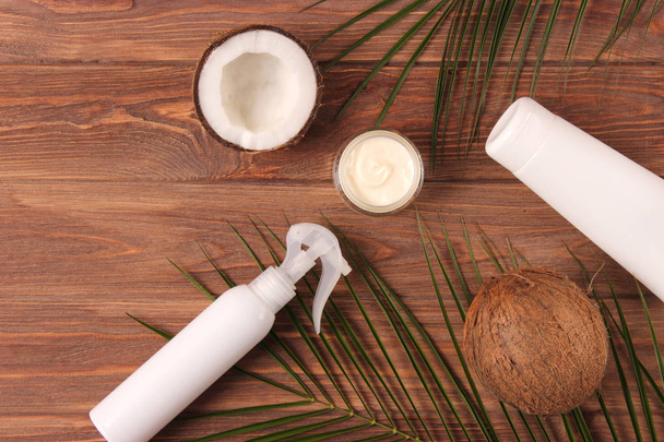 Kokosnuss, tropisches Blatt und Pflegeprodukte auf farbigem Hintergrund von oben. Kosmetik mit Kokosextrakt für Haare, Körper, Gesicht. Hautpflege, Hautfeuchtigkeit. Flatlay - Foto, Bild
