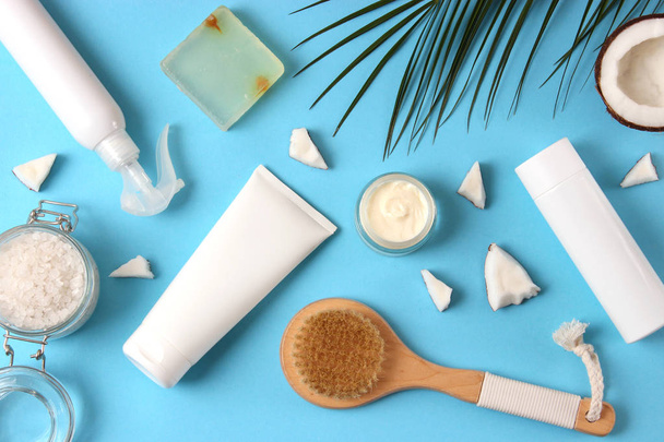 Coconut, tropical leaf and care products on a colored background top view. Cosmetics with coconut extract for hair, body, face. Skin care, skin hydration. flatlay - Valokuva, kuva