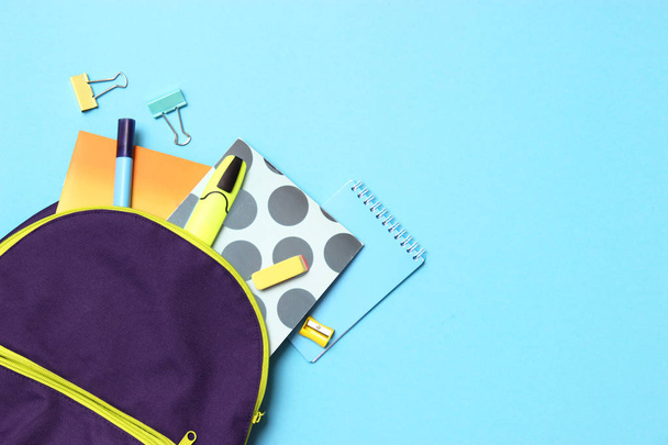 σχολική τσάντα και σχολικά χαρτικά σε έγχρωμο φόντο πάνω όψη. Αντίληψη πίσω στο σχολείο. - Φωτογραφία, εικόνα