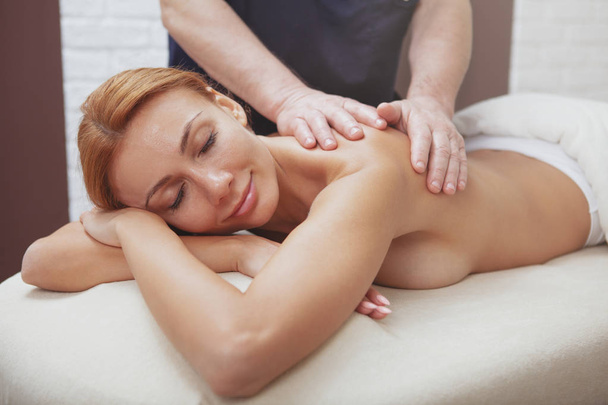 Чудова жінка насолоджується повним масажем тіла в спа-центрі
 - Фото, зображення