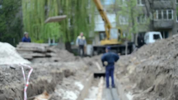 Werknemers met bouw kraan bedekken nieuwe waterleidingen met betonnen platen - Video